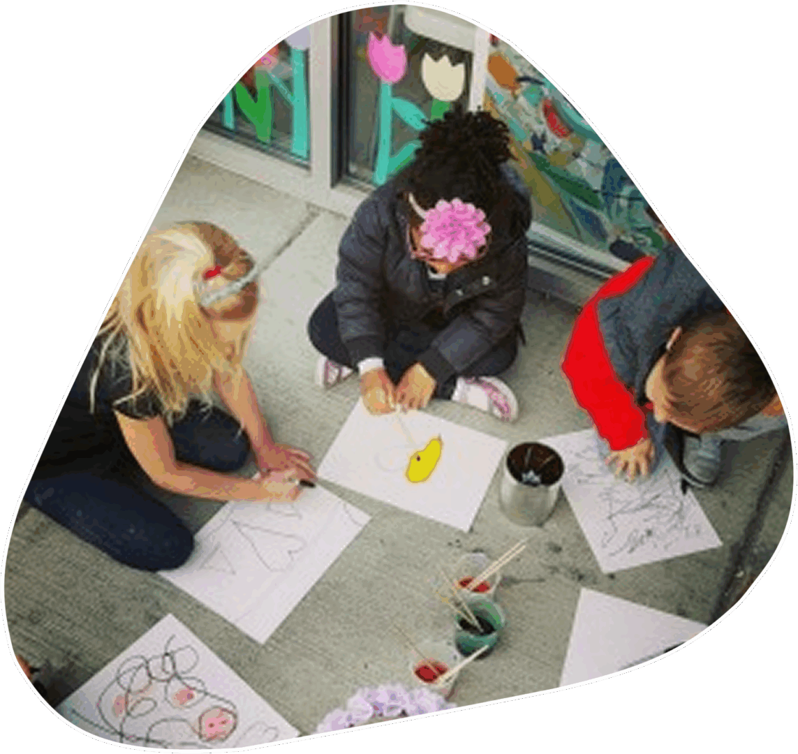 Three children sitting on the floor drawing pictures.
