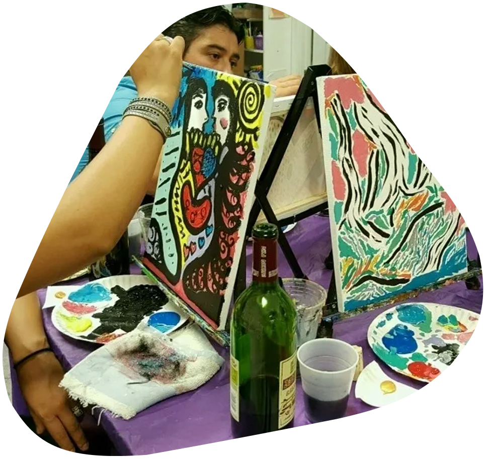 image-1 A person sitting at a table with two paintings.