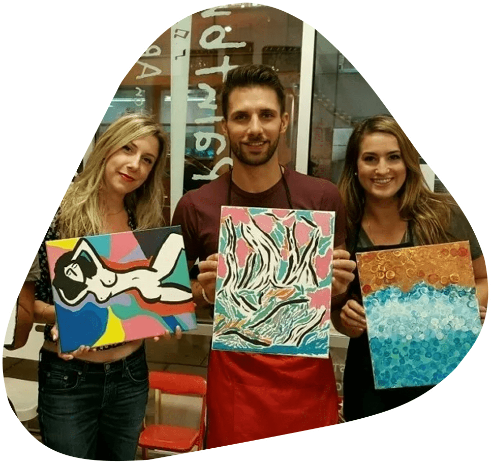 image-12 Three people holding up paintings in front of a store window.