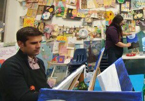 A man and woman in front of a wall covered with pictures.