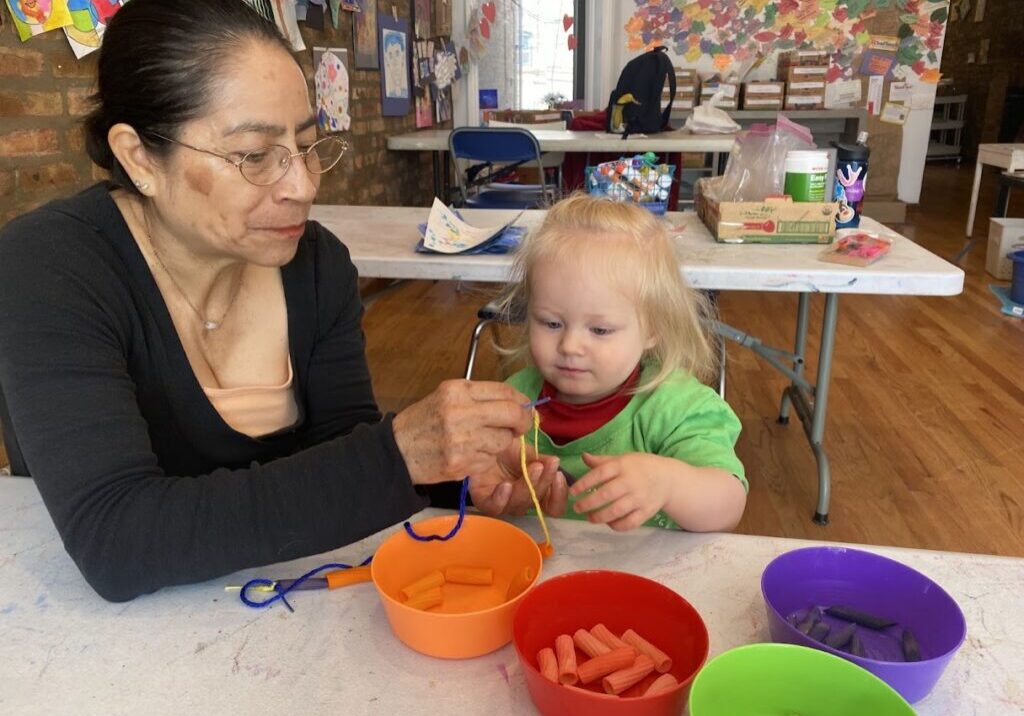 A woman and child at table with bowls of food.